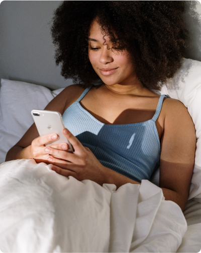 Woman laying in bed looking at phone